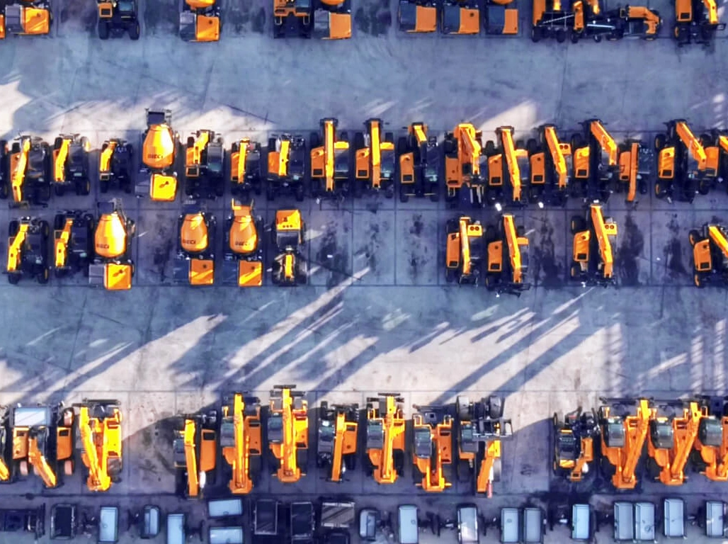aerial view of a yard full of telehandlers, mixers, and dumper trucks