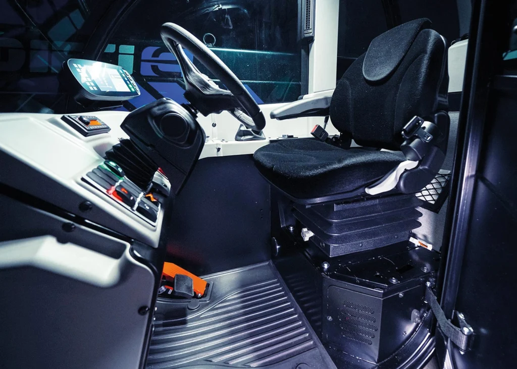 Interior view of the apollo-e electric telehandler showing the seat and steering wheel
