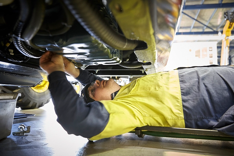 A technician doing routine maintenance on a Dieci telehandler