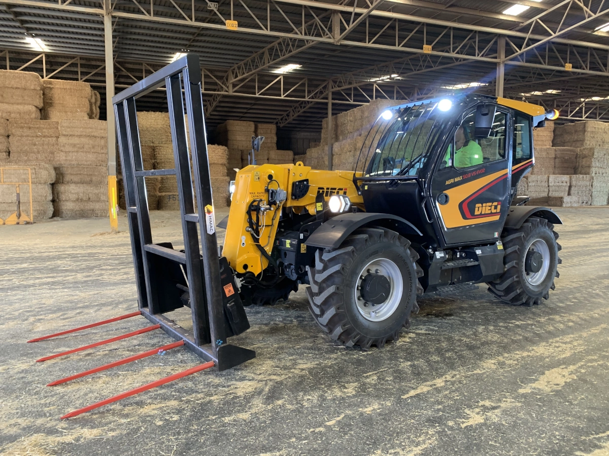 A Dieci Agricultural telehandler in a farm shed fitted with a hay fork attachment