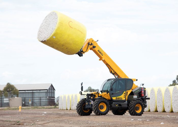left side view of a Dieci Cotton Pro 7t Telehandler carrying a cotton bale raised high in the air