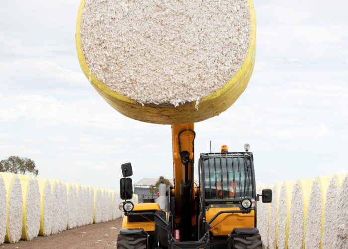 front view of a Dieci Cotton Pro 7t Telehandler carrying a cotton bale raised high in the air