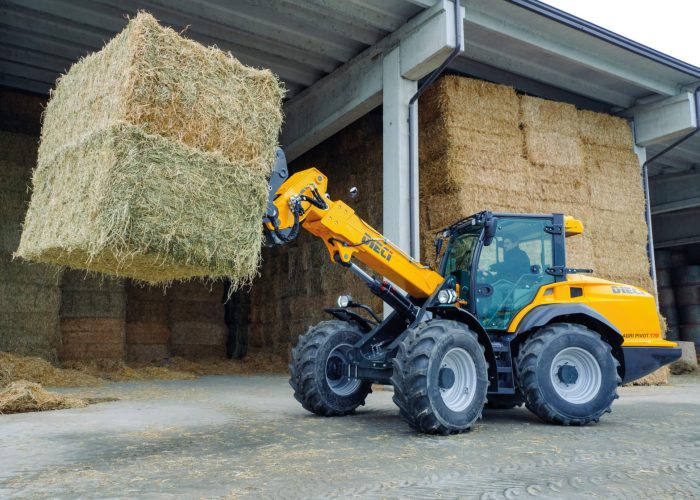 left view of a Agri Pivot T70 3t Telescopic Loader moving large hay bales out of a shed on a farm in Australia