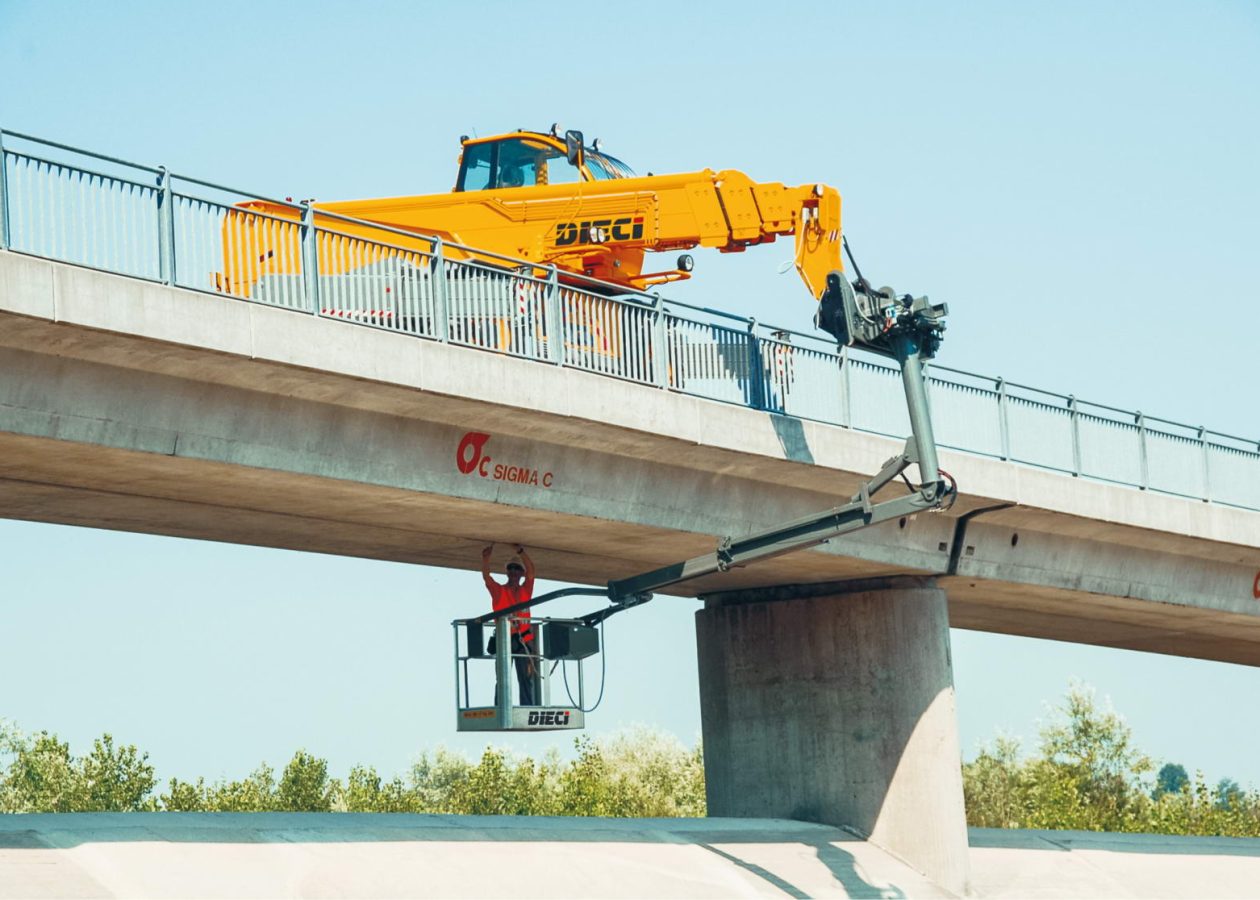 Pegasus 50.21 rotating telehandler working on a bridge with an EWP elevated work platform