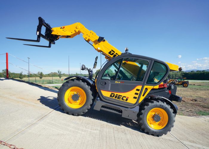 Left side view of the Zeus 35.10 3.5T Telehandler sitting on a concrete incline slope with its boom and forks raised in the air