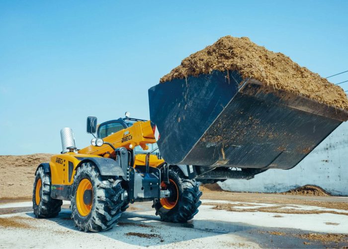 Agri Max 7t Telehandler carrying a full load of dirt and hay in its bucket