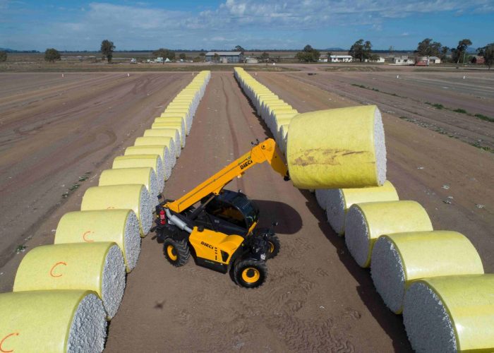 right side top down view of a Dieci Cotton Pro 7t Telehandler carrying a cotton bale raised high in the air