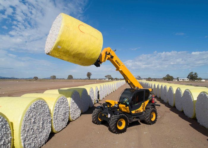 A Dieci telehandler lifts a yellow baled cotton roll among rows of white cotton bales