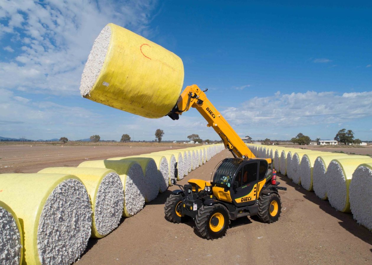 A Dieci telehandler lifts a yellow baled cotton roll among rows of white cotton bales