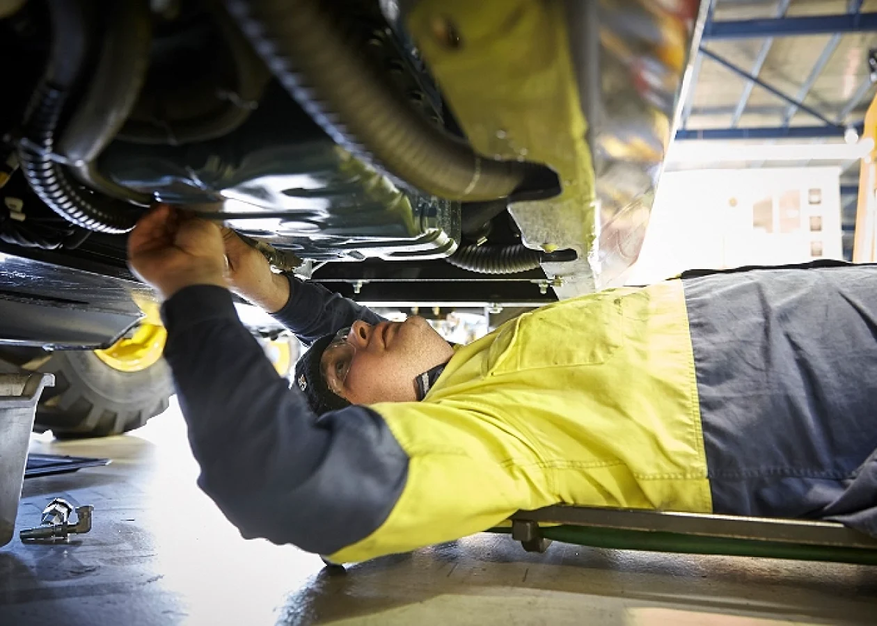 A technician doing routine maintenance on a Dieci telehandler