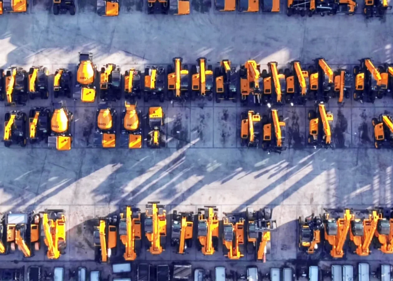 aerial view of a yard full of telehandlers, mixers, and dumper trucks