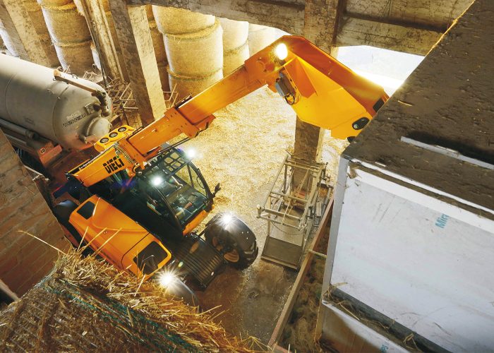 Poultry Pro 3t Telehandler scooping materials and feed out of a large truck