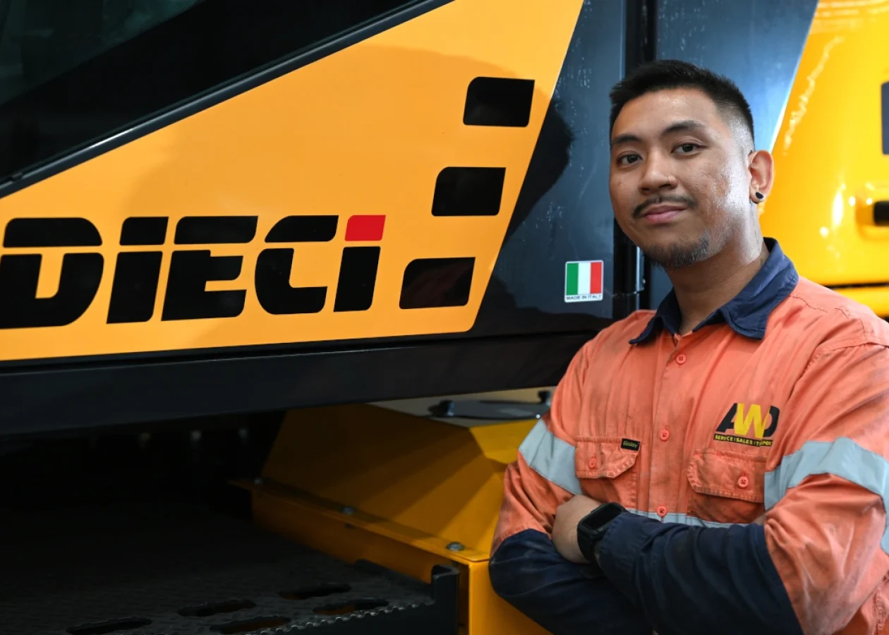 a Dieci service technician next to a telehandler