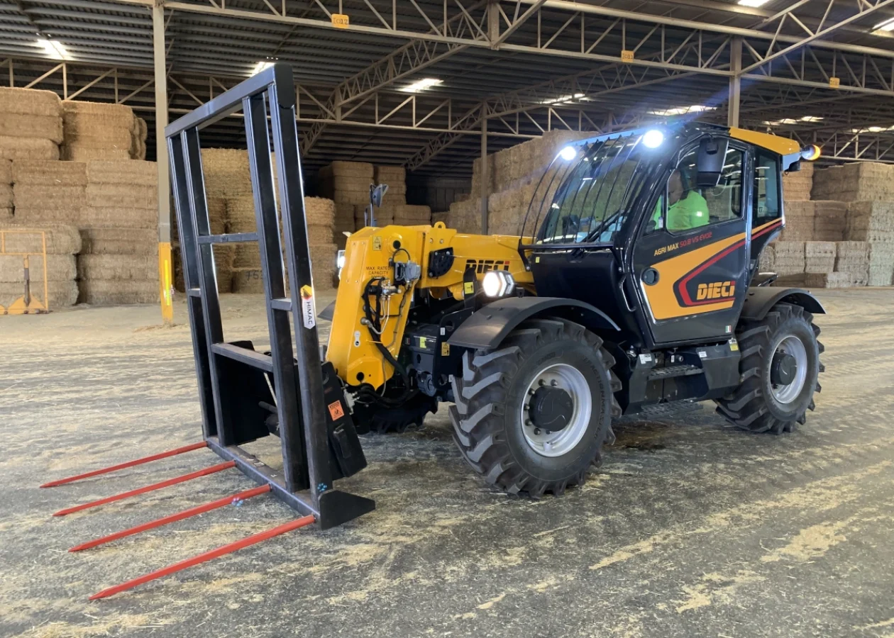A Dieci Agricultural telehandler in a farm shed fitted with a hay fork attachment