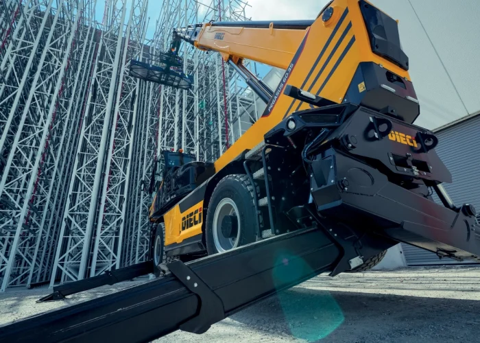 view from low position of a Dieci Pegasus 60.21 6t rotating telehandler with its boom raised and outriggers deployed lifting 6 tonnes on an Australia construction site