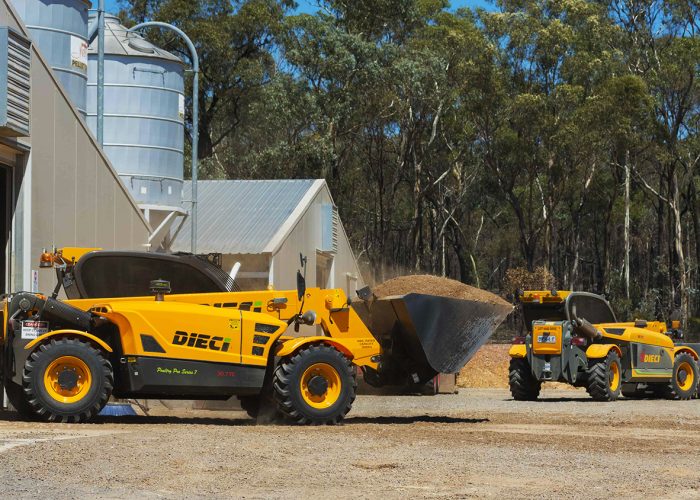 Poultry Pro 3t Telehandler with its boom and bucket lowered and its bucket filled with feed for poultry