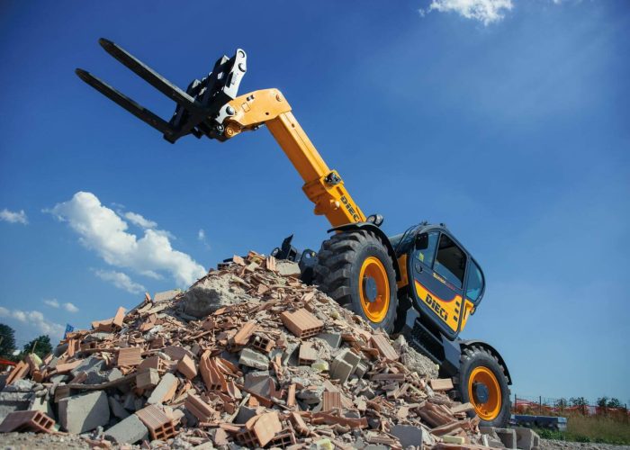 Dieci Samson 70.10 7T Telehandler with its boom raised and lifting forks out stopped on a pile of construction debris on a Sydney construction site