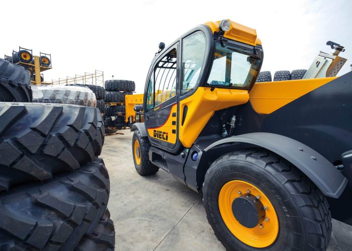 Dieci Samson 70.10 7T Telehandler lifting heavy tyres and maintenance parts in a Sydney repair and maintenance yard