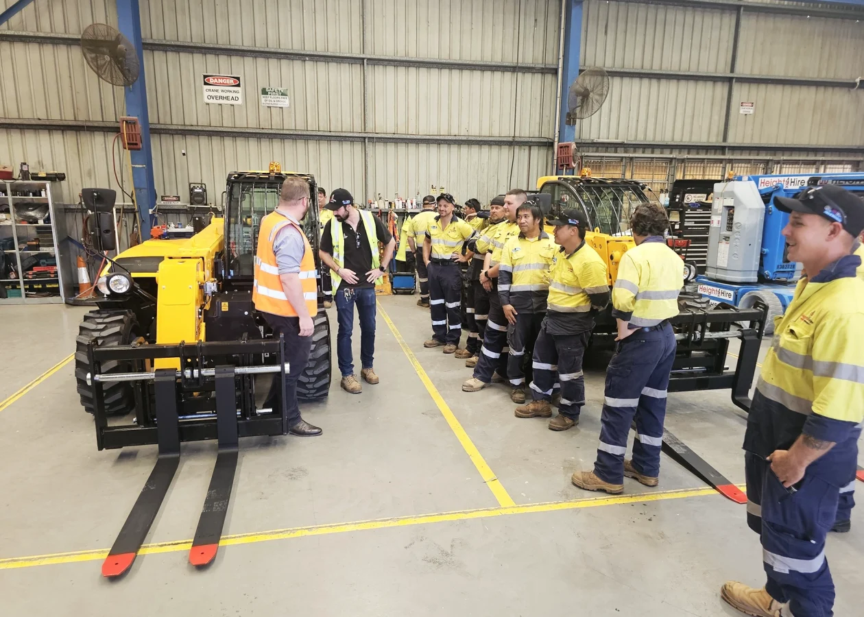 Workers learning about telehandler reliability and maintenance in an Australian workshop